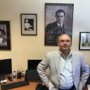 Dr. Carl Eby in his office, with Heminway posters.