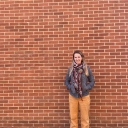 Dr. Bethany Mannon smiles and stands in from of a brick wall.