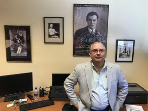 Dr. Carl Eby in his office, with Heminway posters.