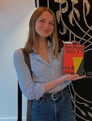 Photo of Charlotte Isenberg holding a copy of magazine titled The Peel