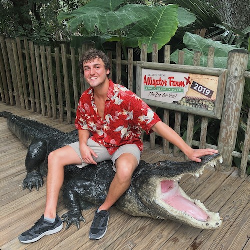 Photo of Nathan Plybon sitting on an alligator.